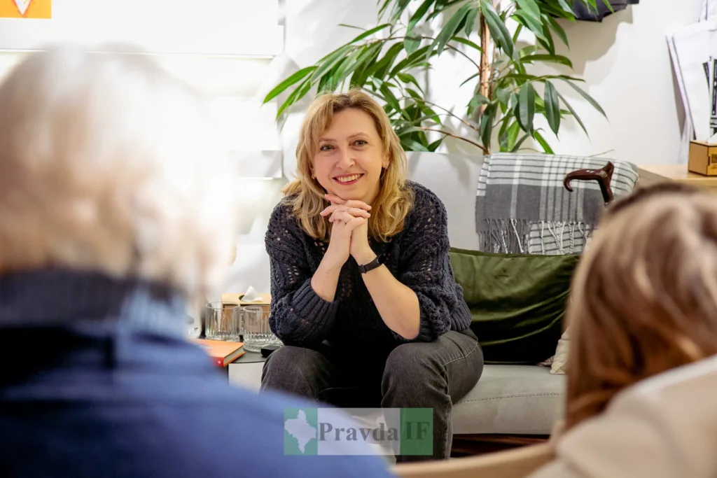 Жінка усміхається під час розмови в кімнаті