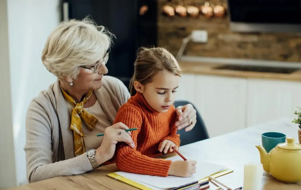 Бабуся допомагає онуці малювати вдома