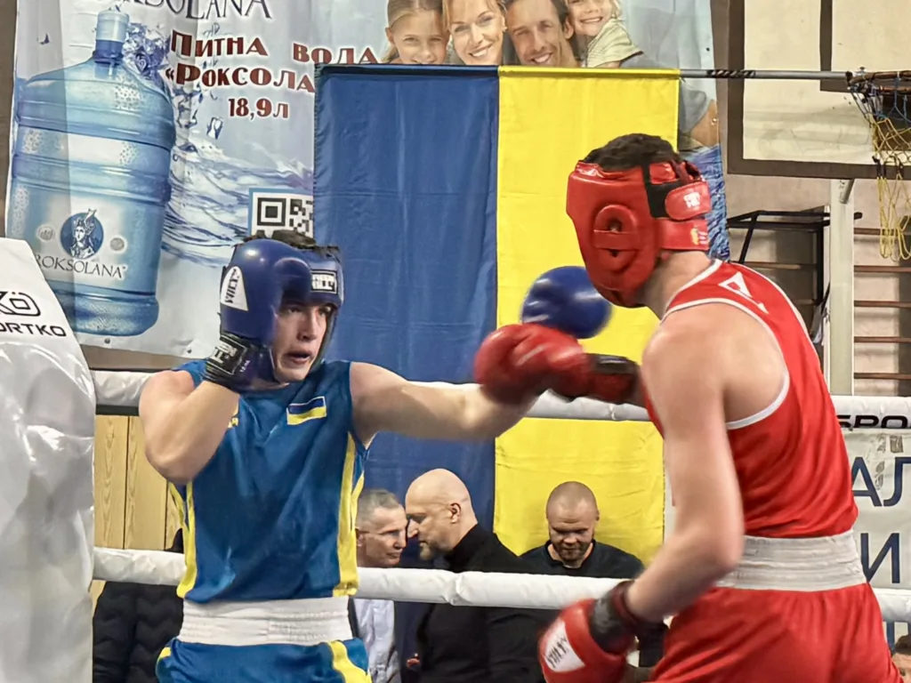 Боксери змагаються на рингу перед українським прапором