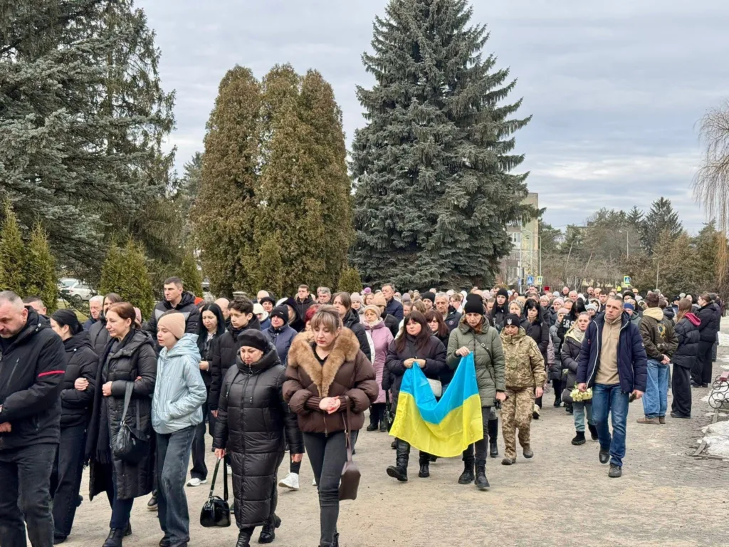 Люди з українським прапором йдуть на вулиці