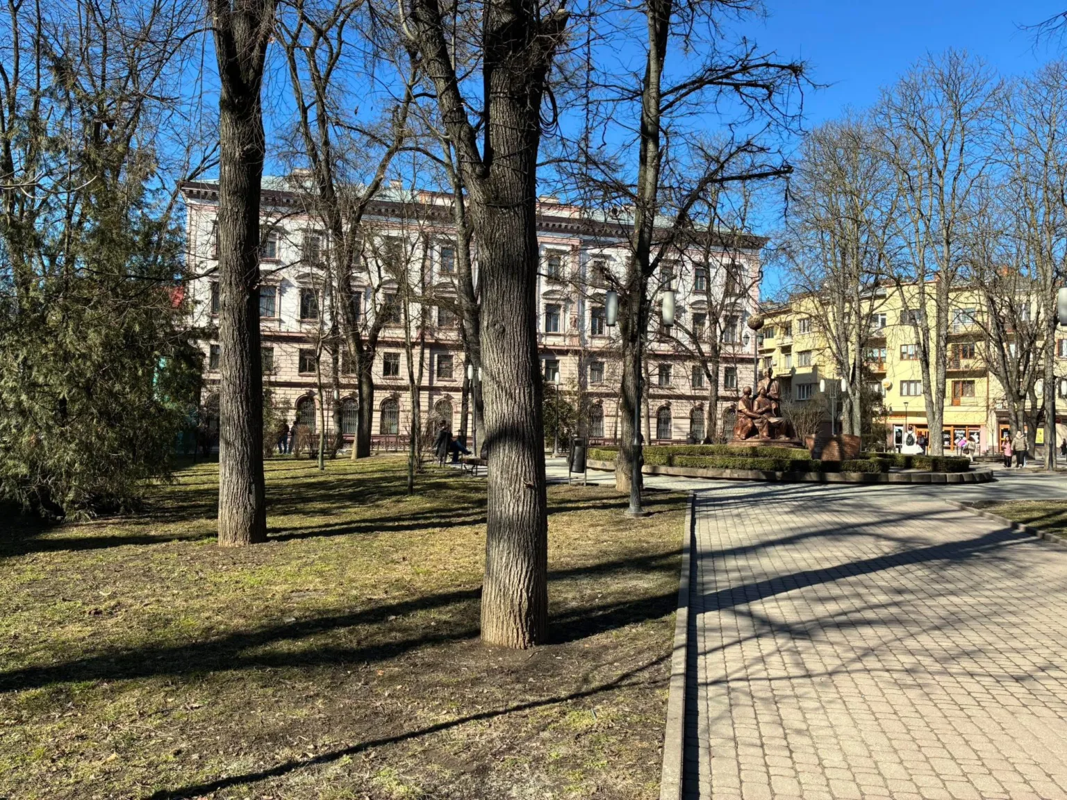 Парк із пам’ятником і старовинною будівлею в місті