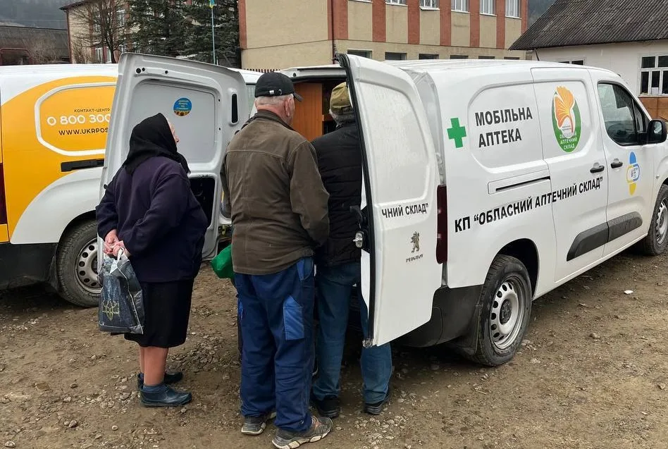 Люди отримують ліки біля мобільної аптеки