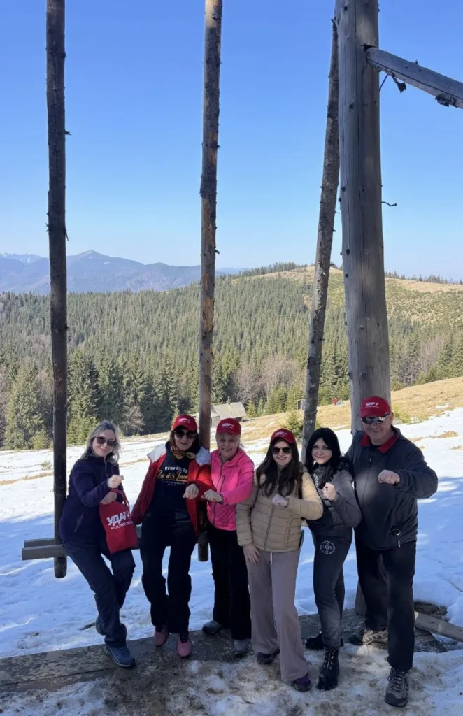 Група людей у горах на снігу з прапорами