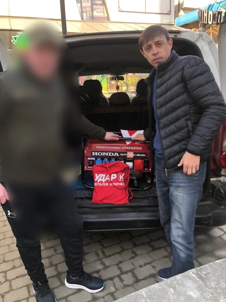 Чоловіки біля генератора Honda в багажнику авто