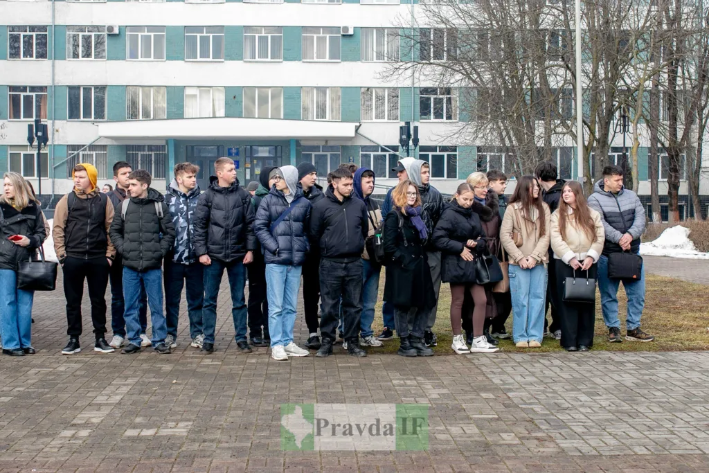 Група студентів стоїть перед університетом взимку