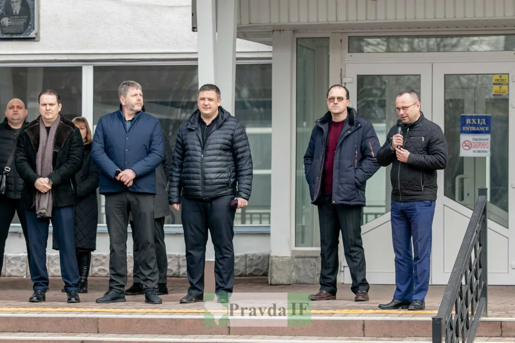 Чоловіки виступають перед будівлею під час події