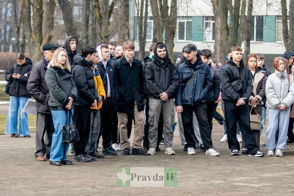 Група людей стоїть на вулиці біля дерев