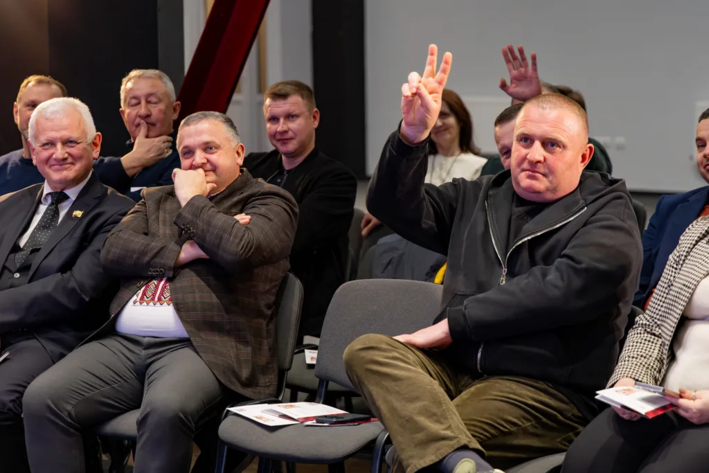 Чоловік піднімає руку під час зустрічі