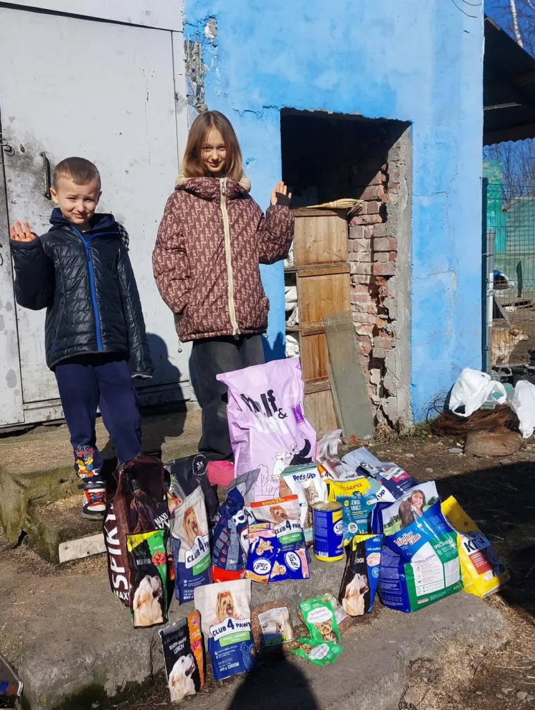Діти з кормом для тварин біля будівлі