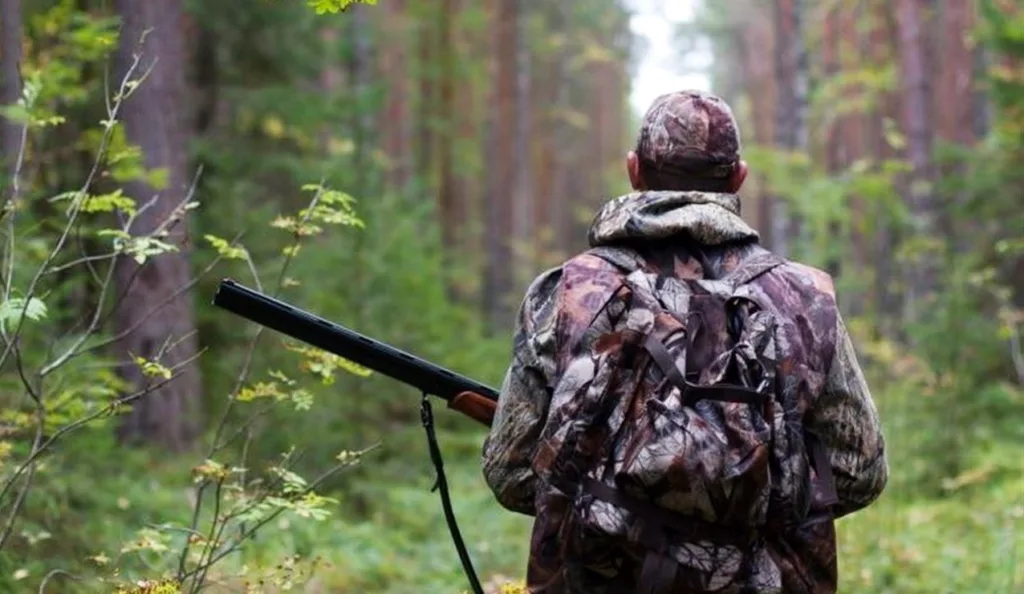 Мисливець у лісі з рушницею