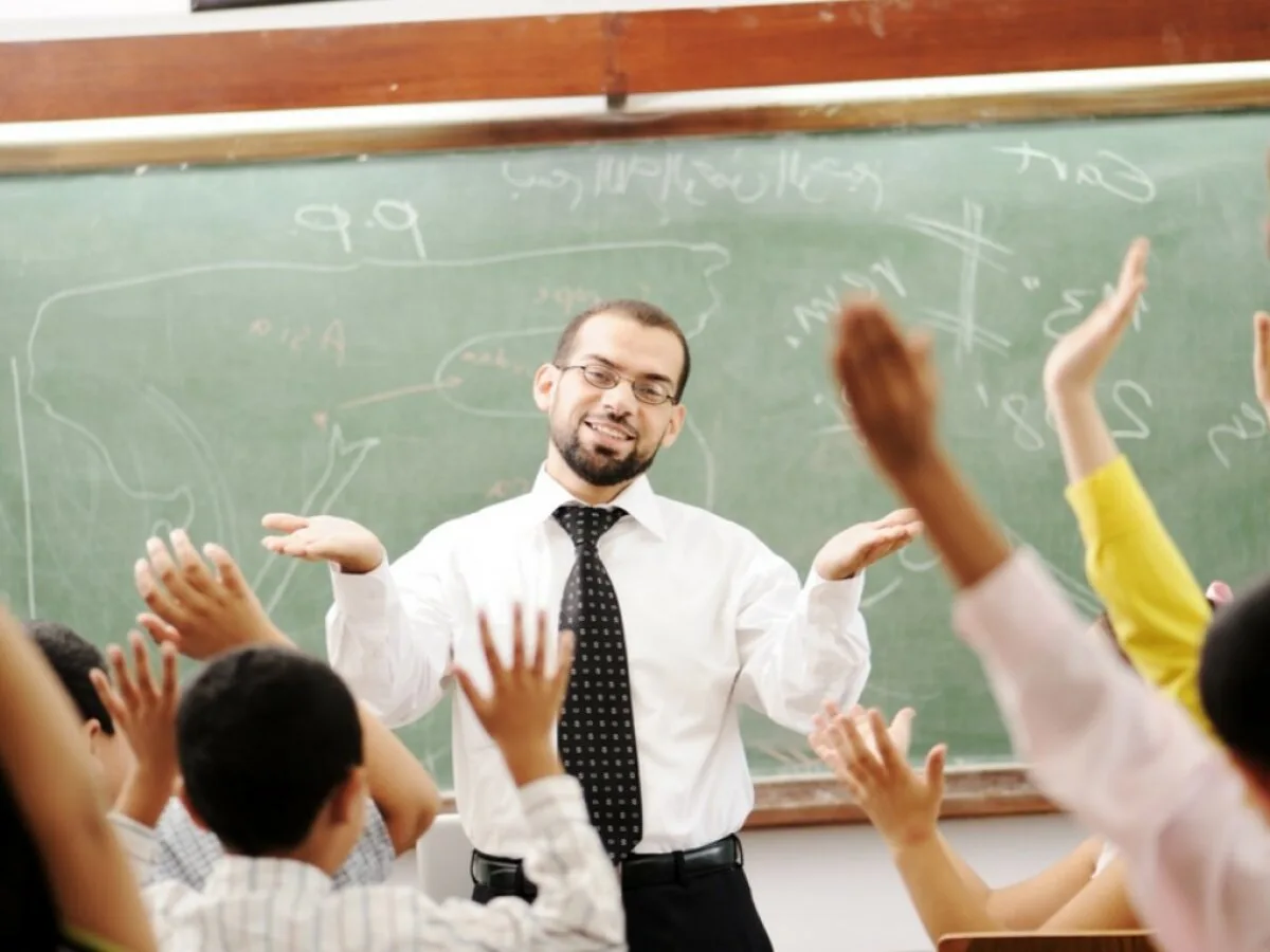 Вчитель відповідає учням у класі біля дошки