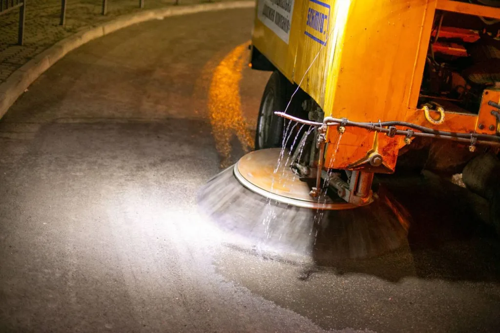 Машина миє міську вулицю вночі