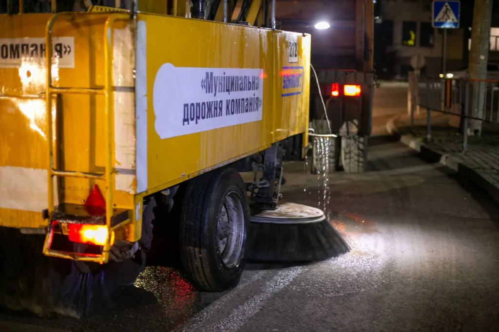 Прибиральна машина миє вулицю вночі