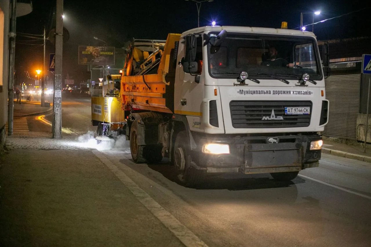 Комунальна вантажівка миє вулицю вночі