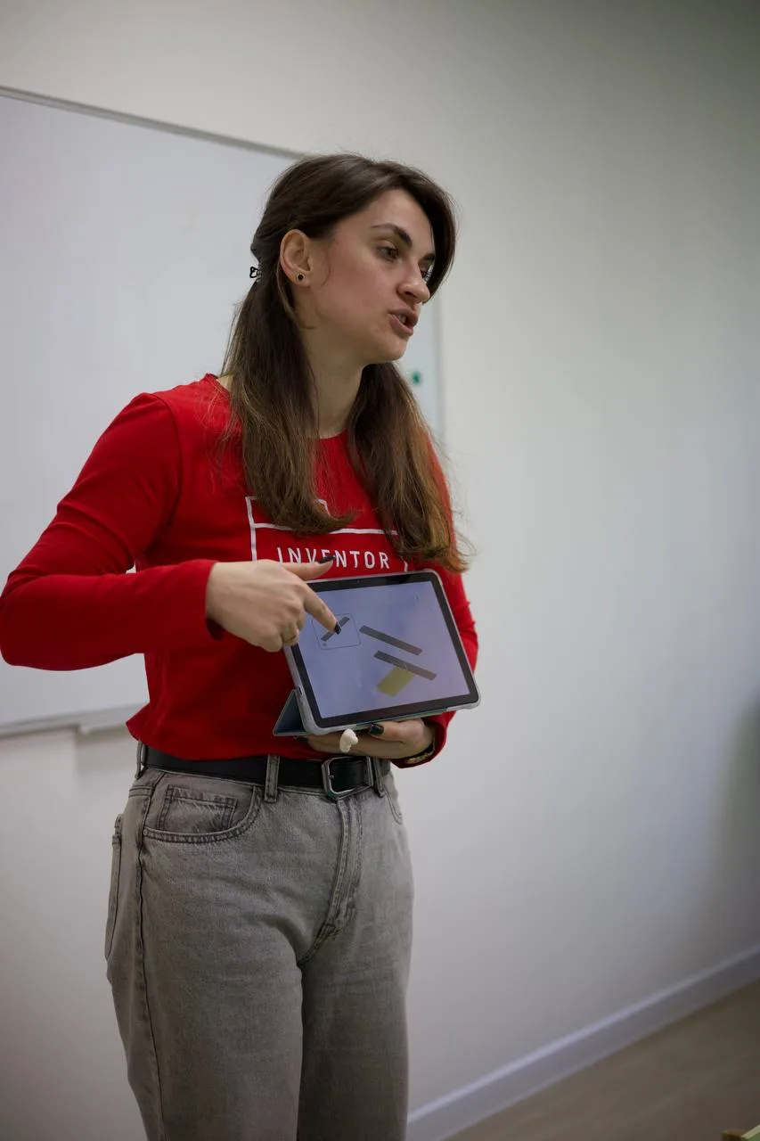 Жінка показує презентацію на планшеті під час уроку