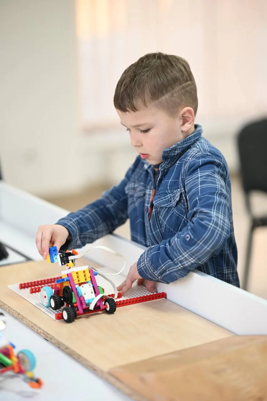 Дитина збирає робот з конструктора LEGO
