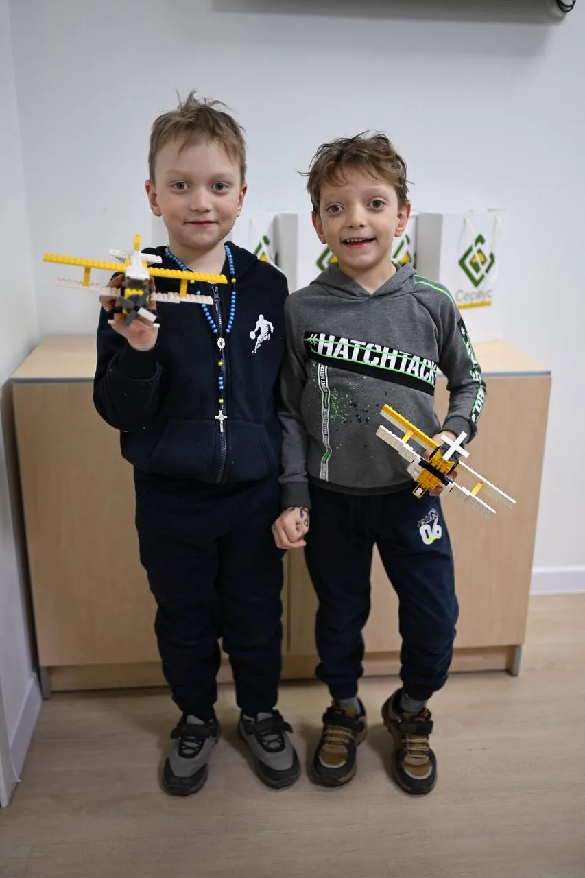 Діти тримають літаки з конструктора LEGO