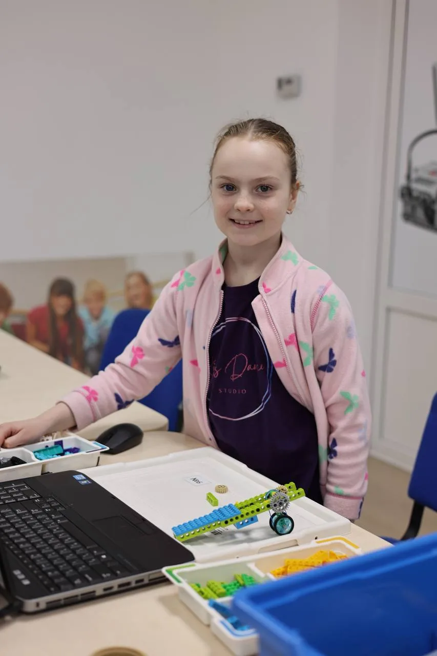 Дівчинка збирає робот з конструктора LEGO