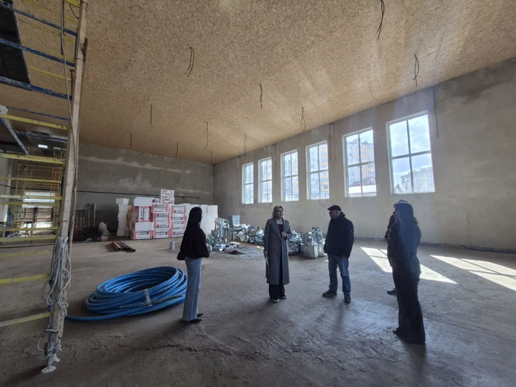 Люди оглядають будівництво всередині великої будівлі