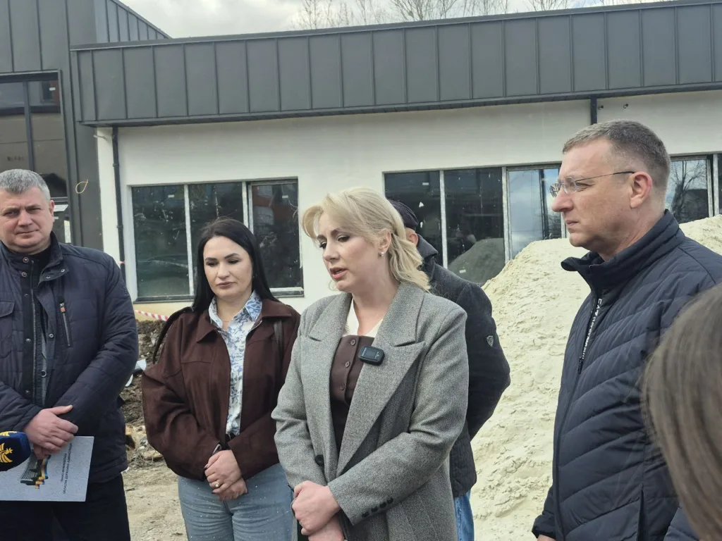 Група людей обговорює будівництво біля сучасної будівлі