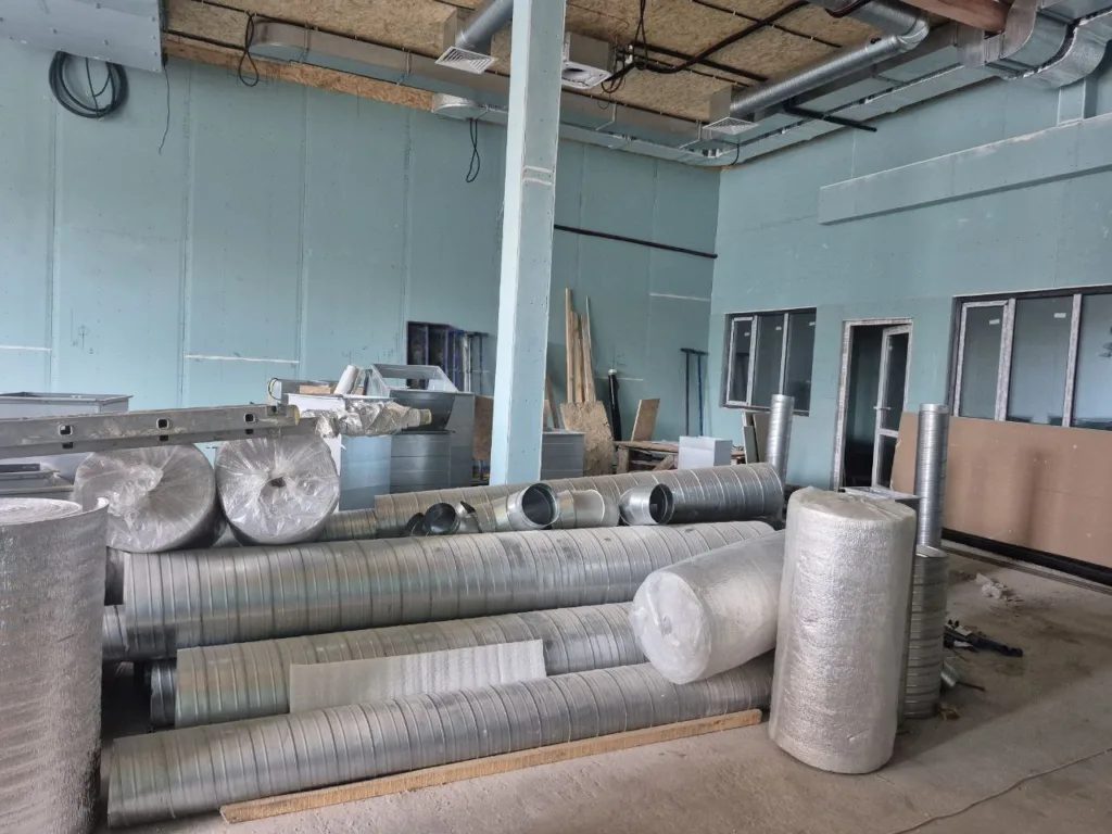 Будівельні матеріали та вентиляційні труби в приміщенні