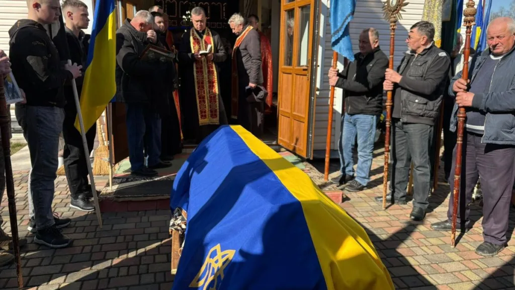 Похоронна церемонія з труною, накритою прапором України