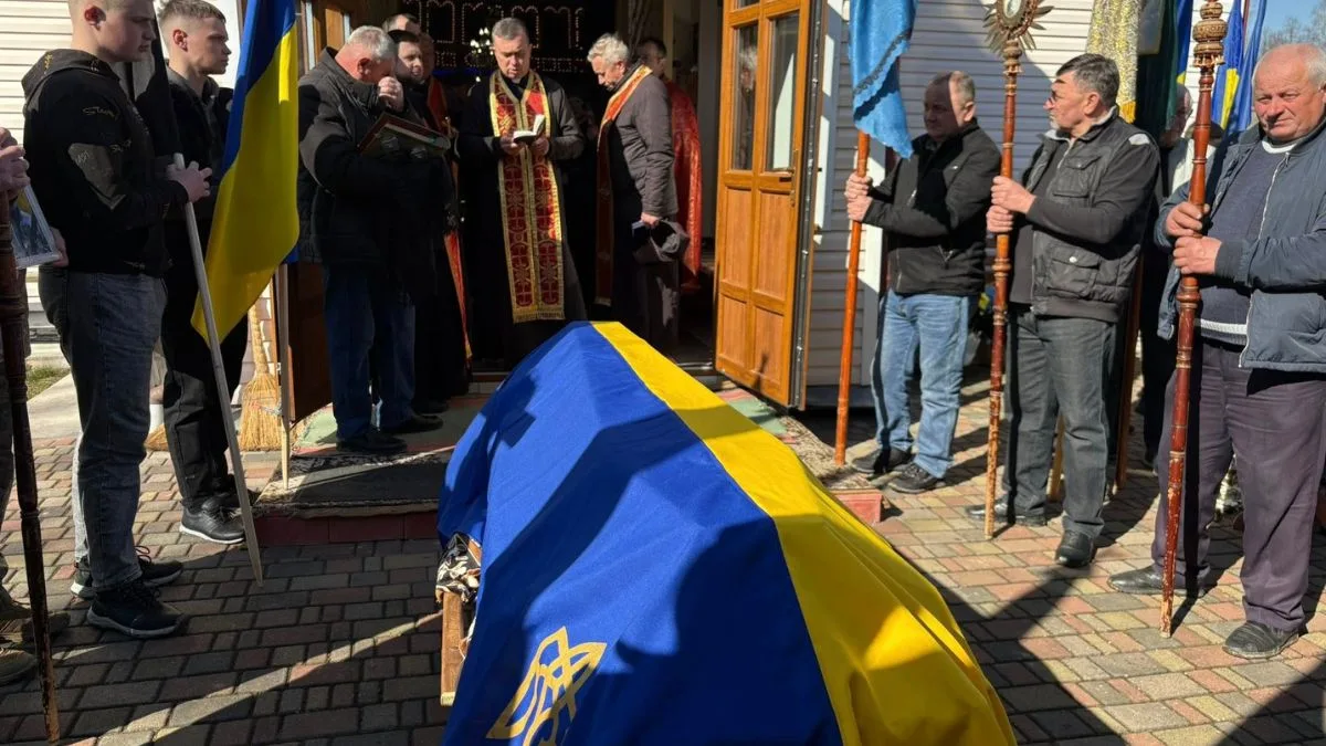 Похоронна церемонія з труною, накритою прапором України