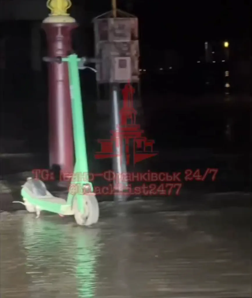 Електросамокат стоїть у воді вночі