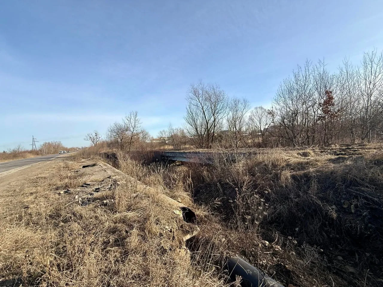 Покинута дорога біля поля з сухою травою