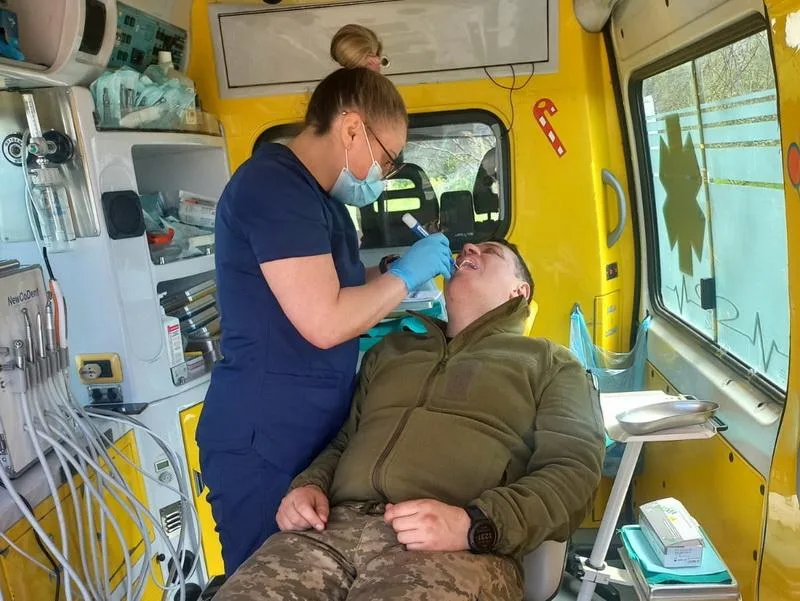 Стоматолог лікує військового в мобільному кабінеті