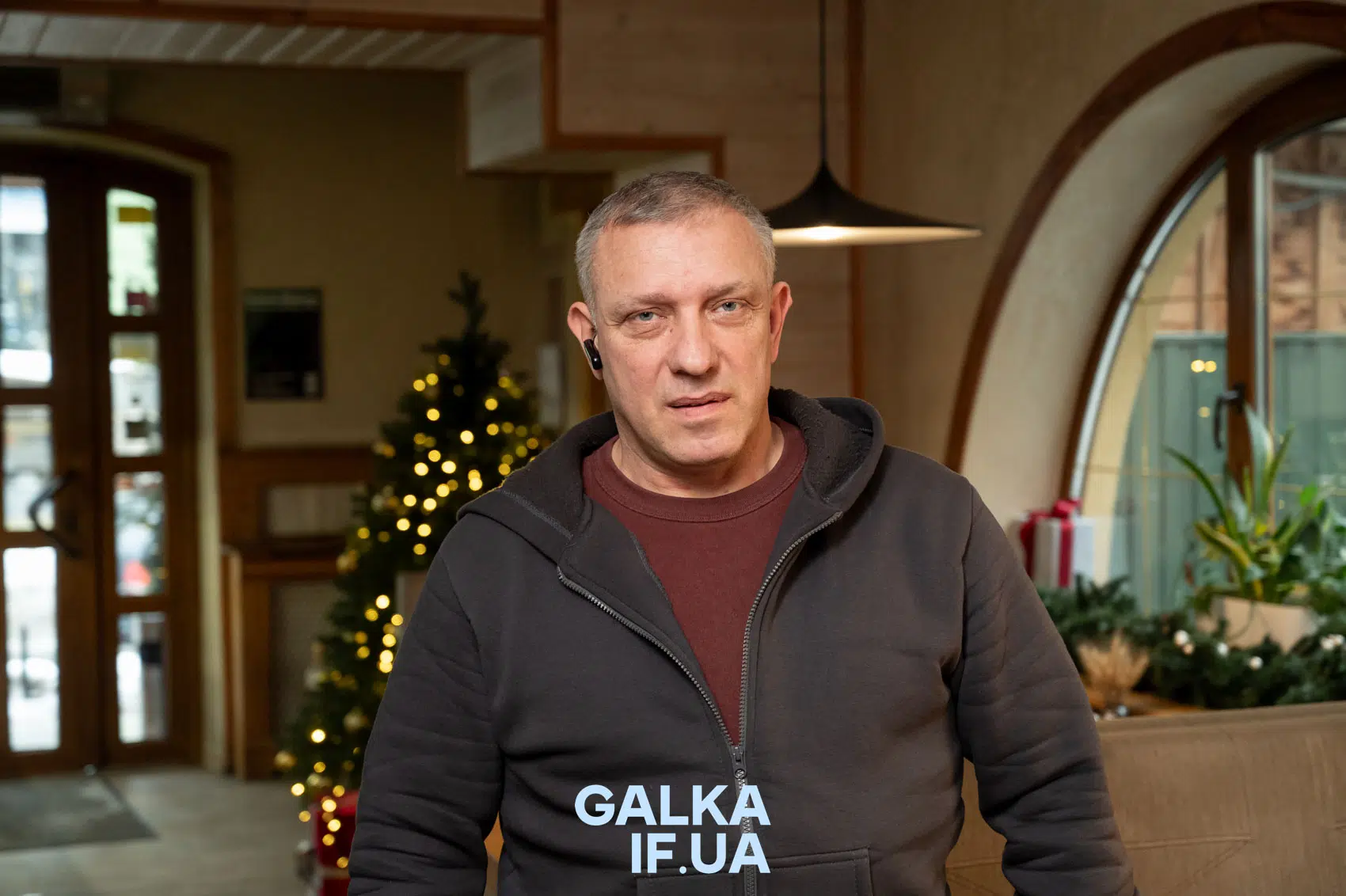 Чоловік у кафе біля новорічної ялинки