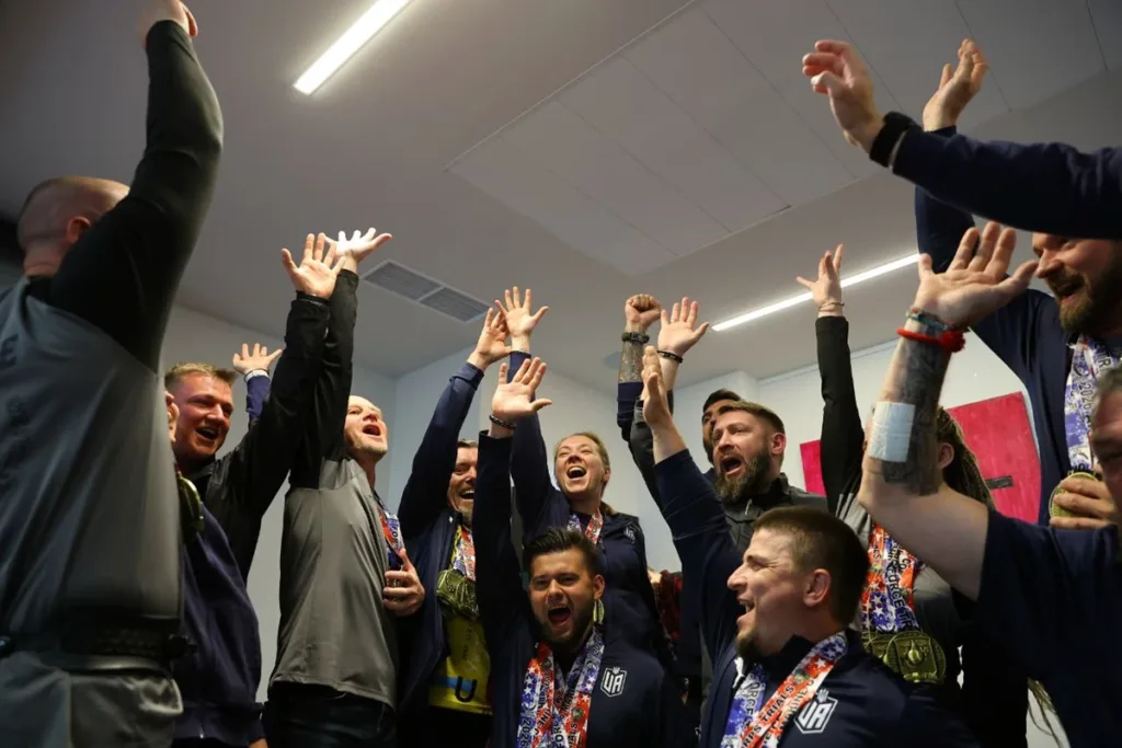 Команда спортсменів святкує перемогу з медалями