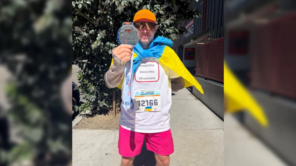 Марафонець з медаллю та українським прапором