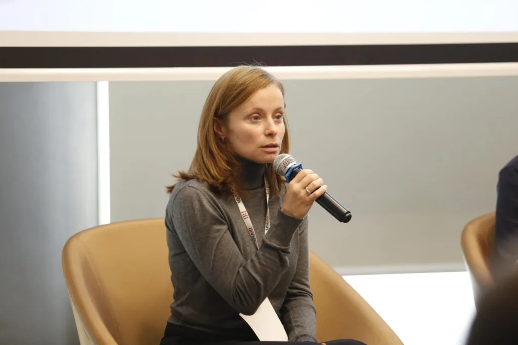 Жінка говорить у мікрофон під час конференції