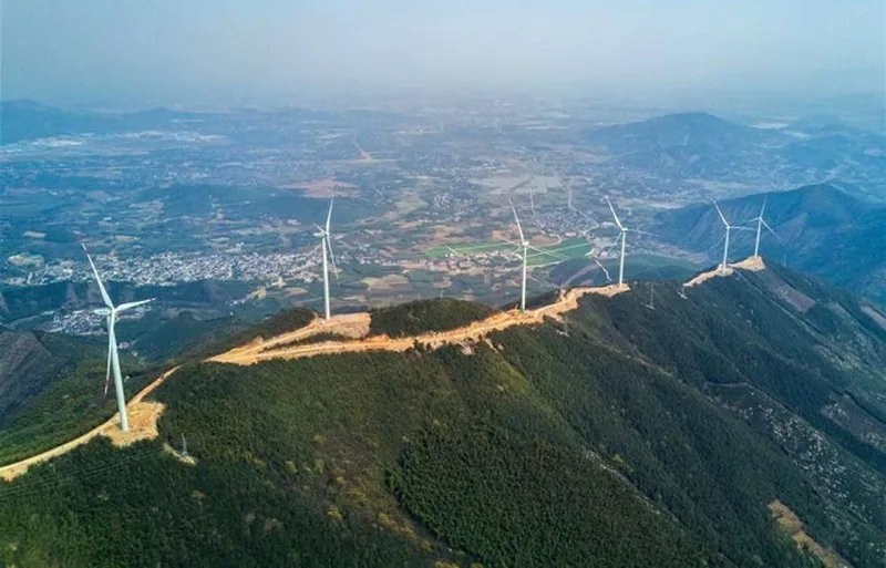 Вітрові турбіни на гірському хребті над містом