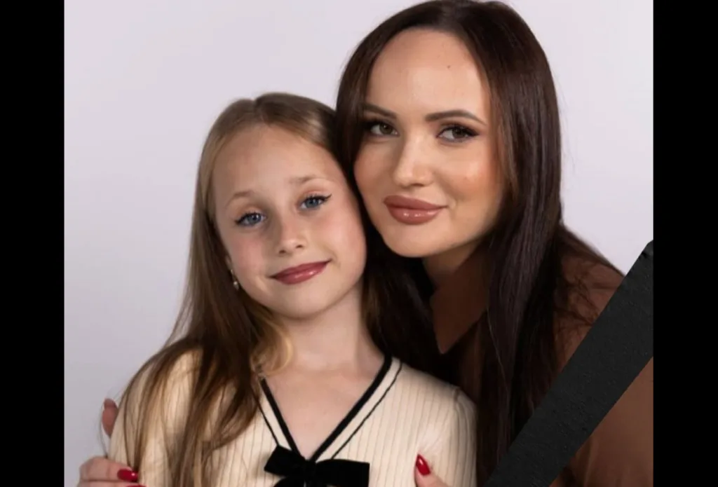 Жінка обіймає дівчинку, посміхаються до камери