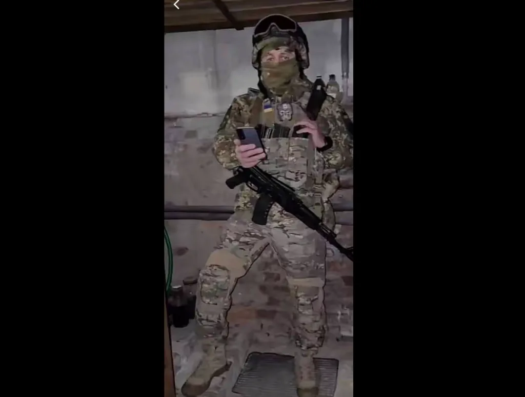 Український військовий у камуфляжі тримає зброю