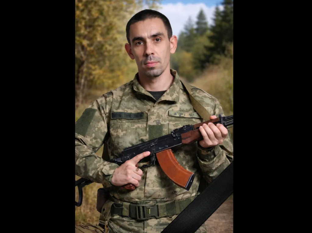 Український військовий у камуфляжі з автоматом