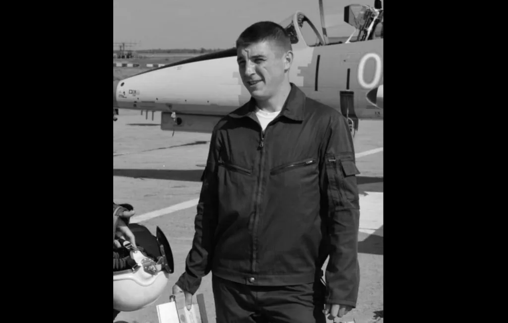 Пілот стоїть біля військового літака на аеродромі