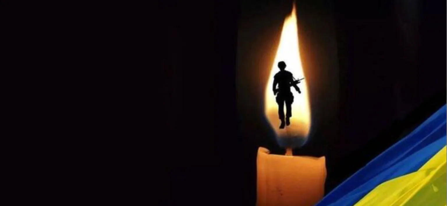 Свічка пам’яті воїна на тлі прапора України