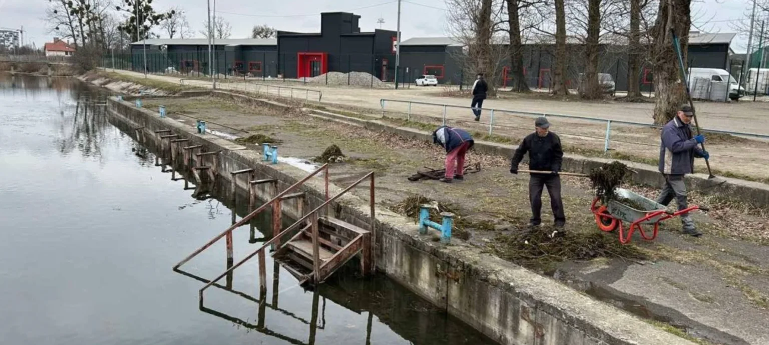 Люди прибирають берегову зону біля водойми