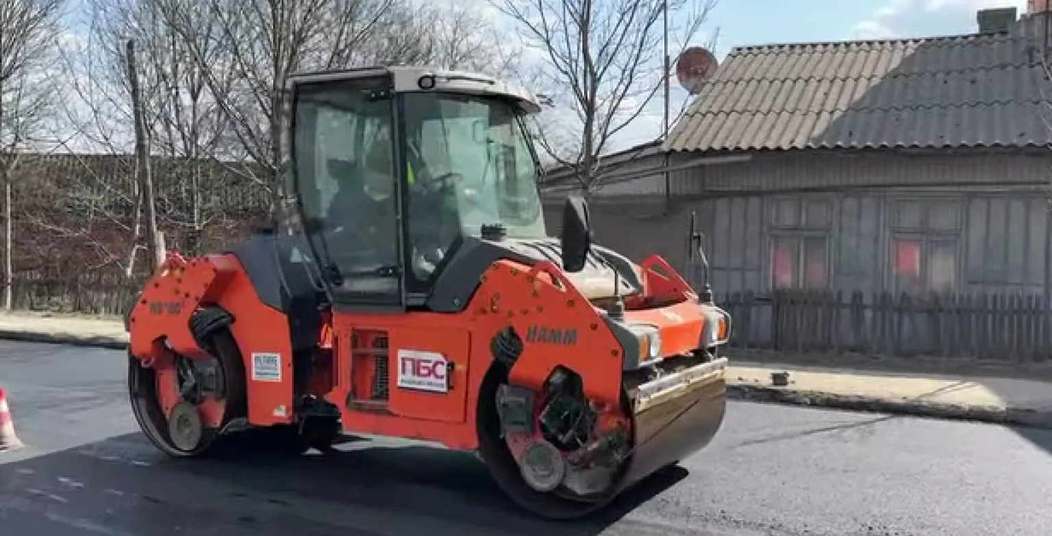 Асфальтоукладальний каток ремонтує дорогу біля будинку