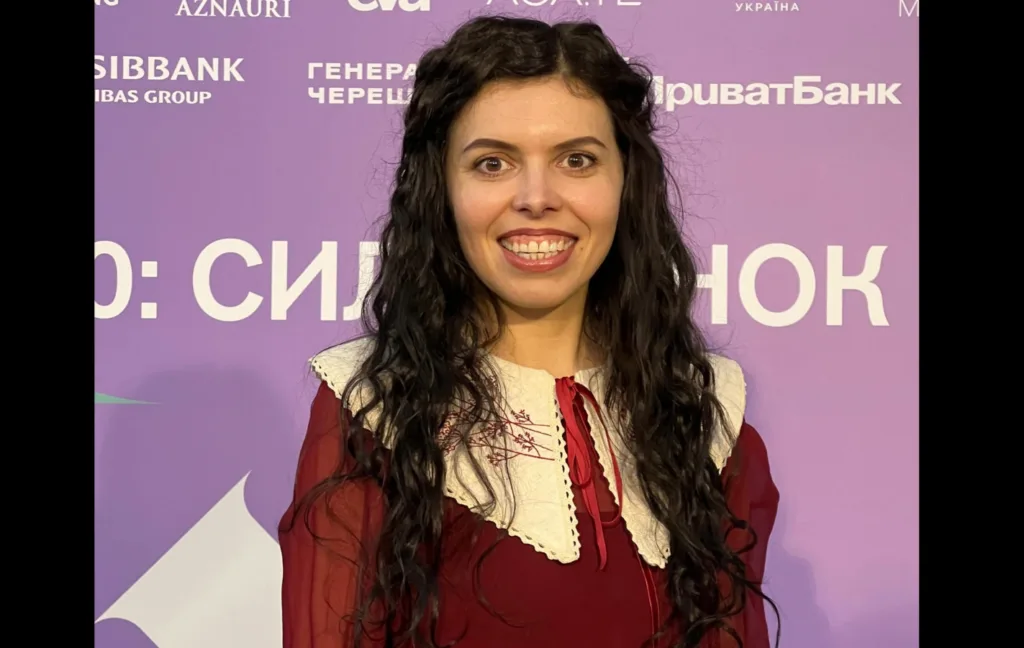 Жінка з темним волоссям на фіолетовому тлі