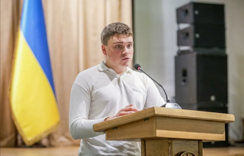 Молодий чоловік виступає на трибуні з мікрофоном