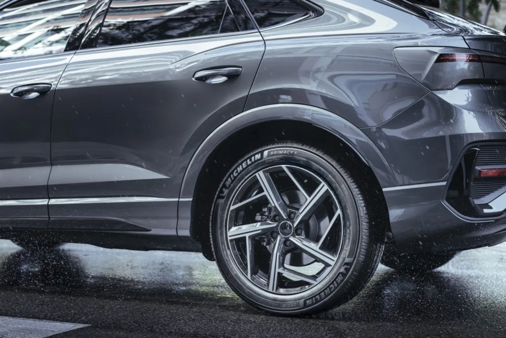 Задня частина сірого автомобіля на дощовій дорозі