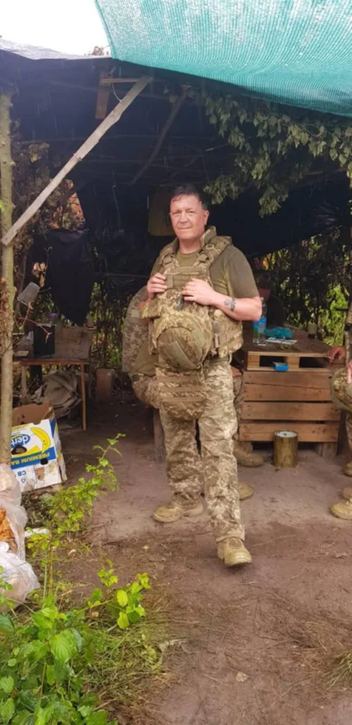 Військовий у камуфляжі стоїть у польовому таборі