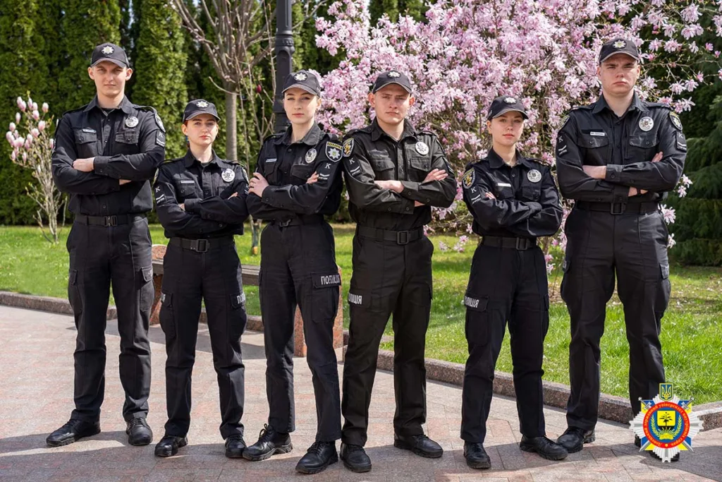 Курсанти поліції стоять перед цвітучими деревами