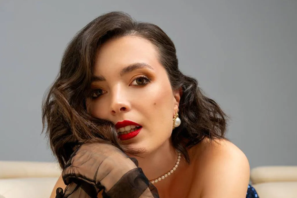 Жінка з червоною помадою та перловими сережками