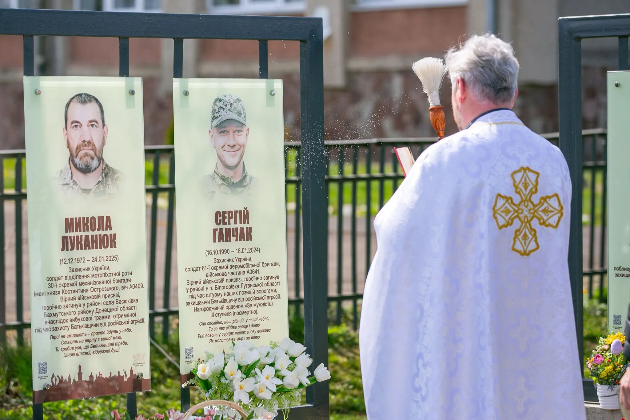Священник освячує меморіал загиблим українським воїнам