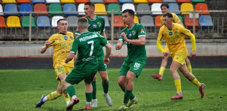 Футбольний матч між командами у жовтій та зеленій формі